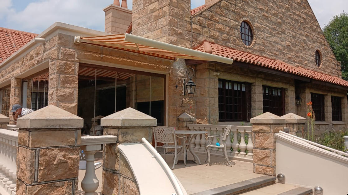 Folding arm awning extended over South African patio entertainment area — Awning Warehouse