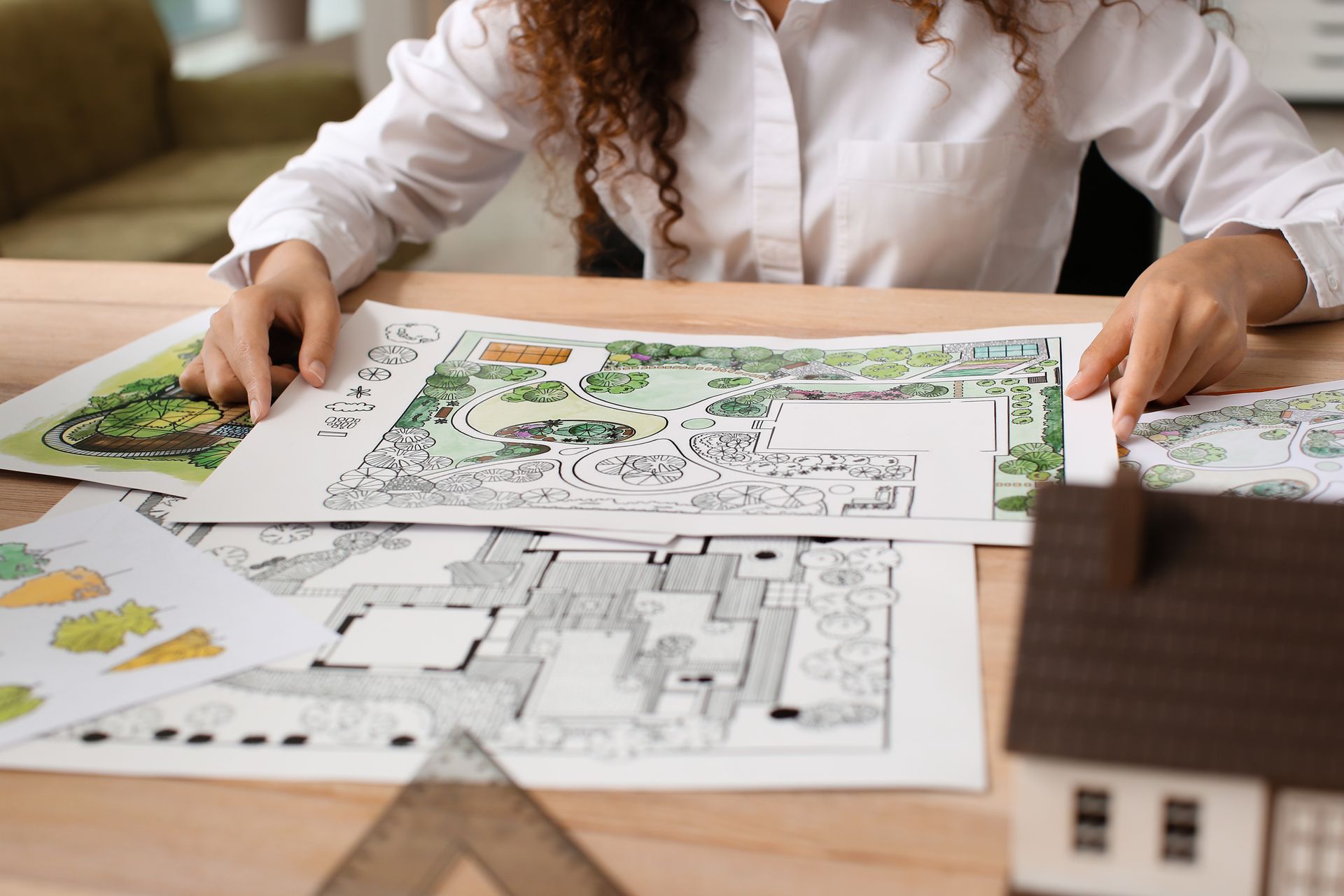 Landscape designer reviewing detailed site plans for a residential outdoor space project.