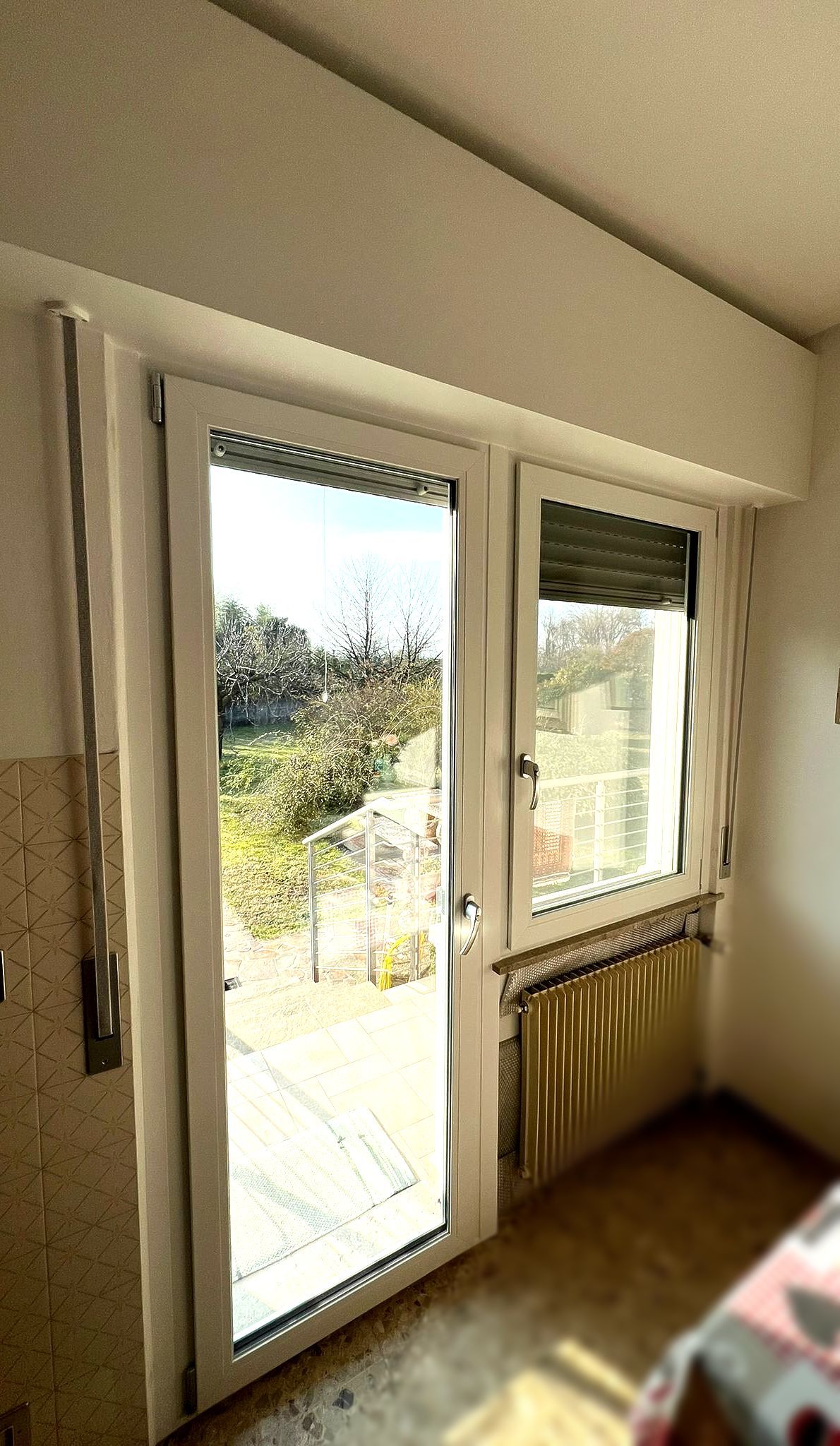 Una cucina con una porta scorrevole in vetro e una finestra.