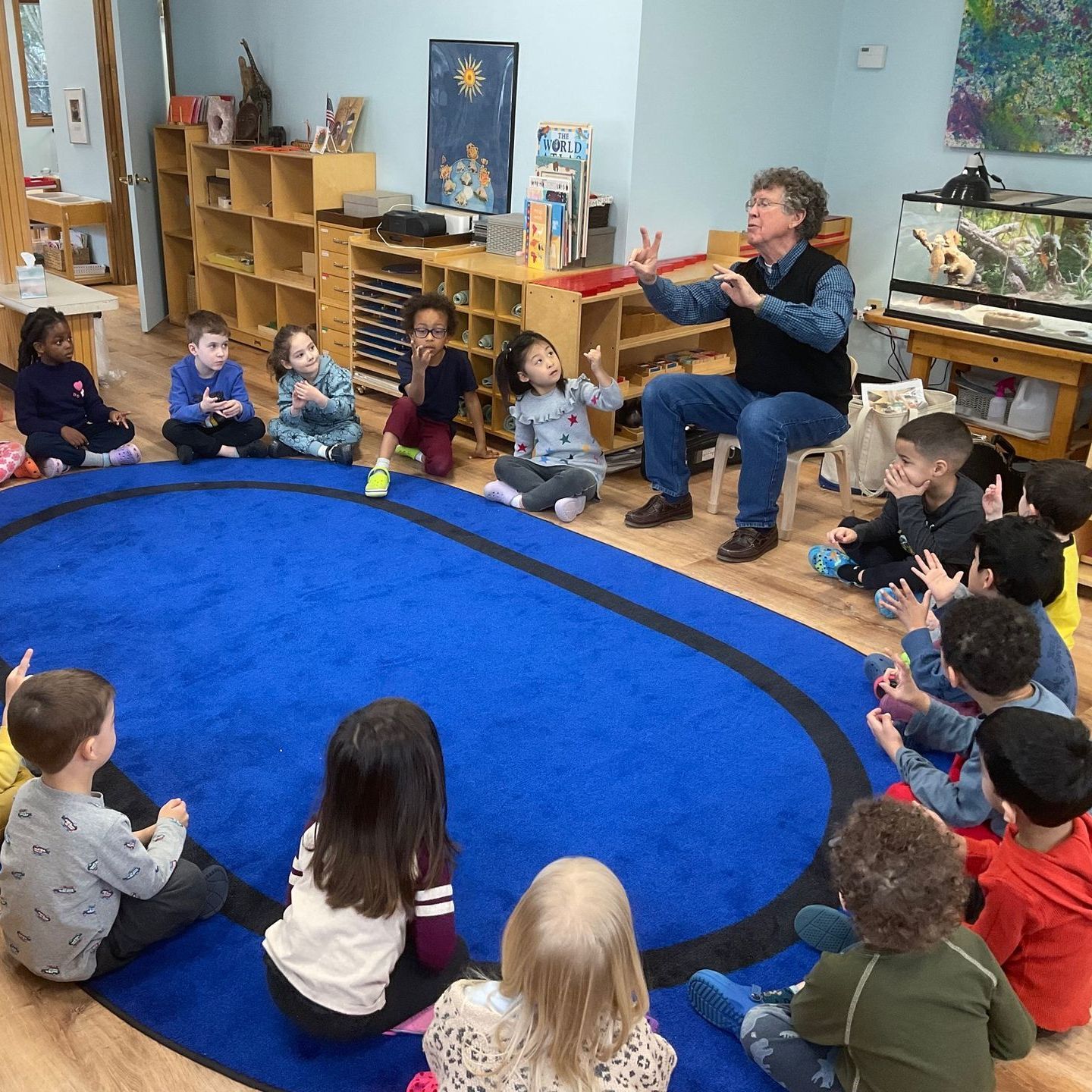 A group of montessori childrens and a montessori guide in the classroom
