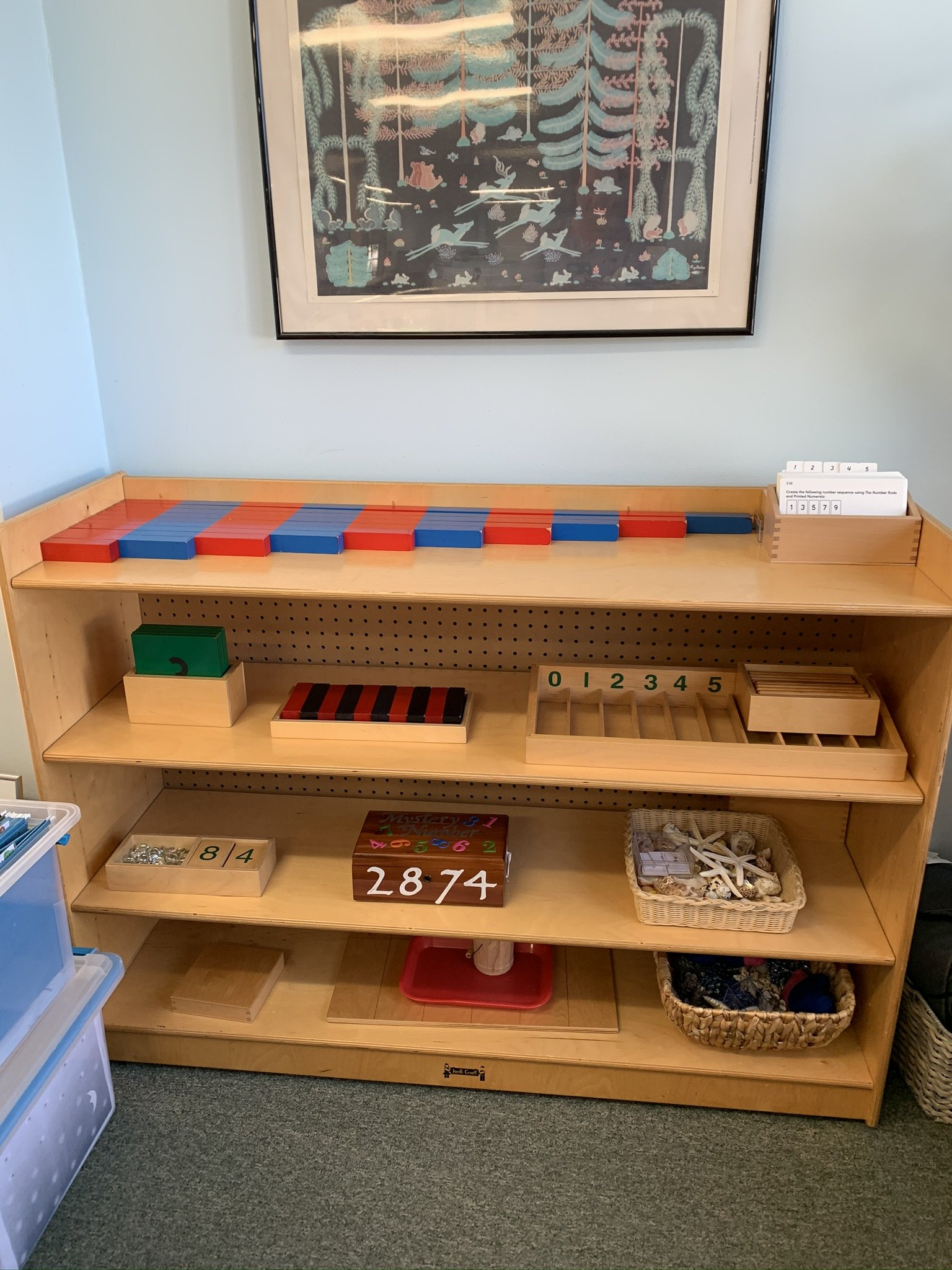 A wooden shelf with montessori materials.