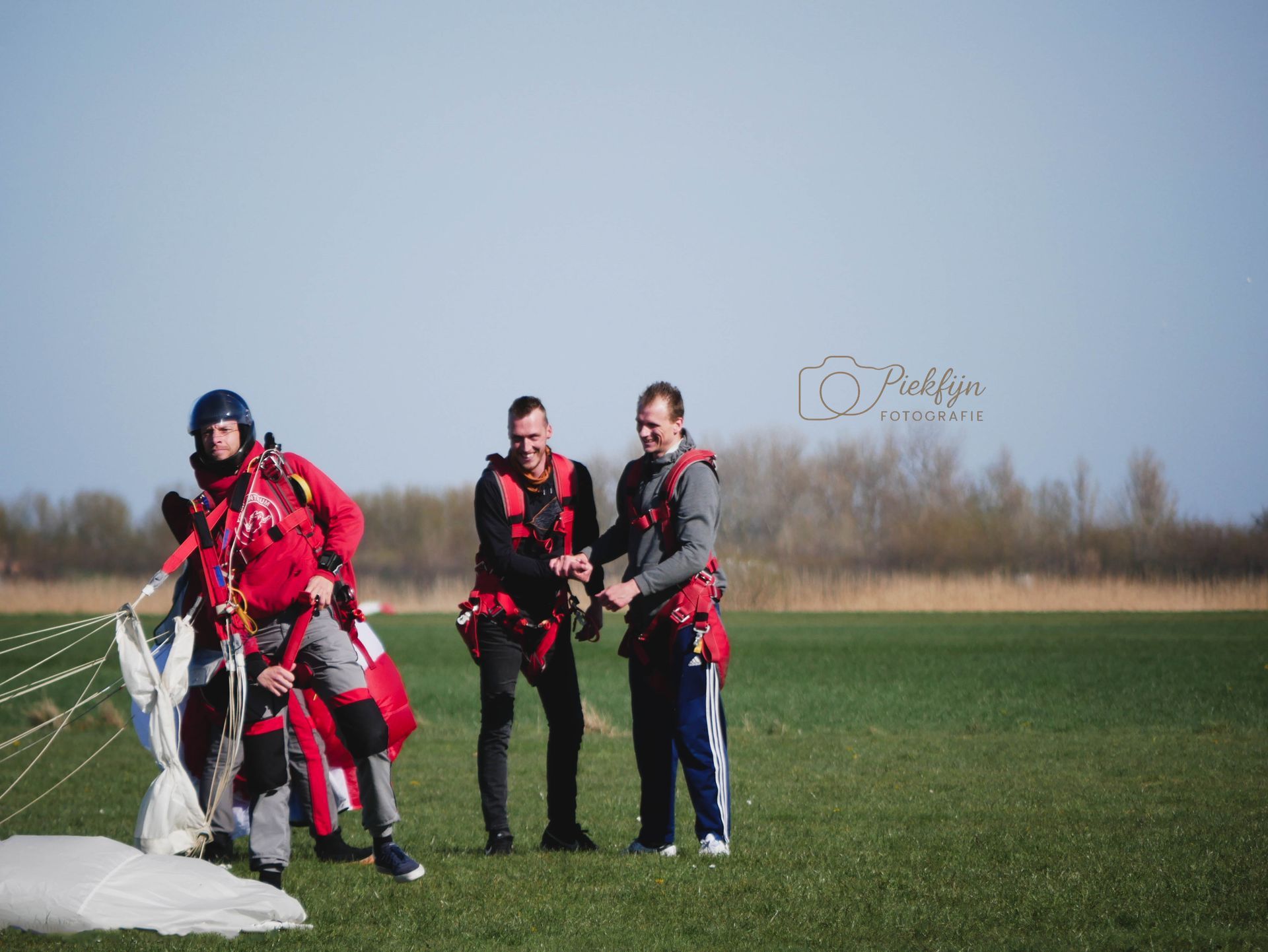 Een groep mensen staat op een weelderig groen veld.