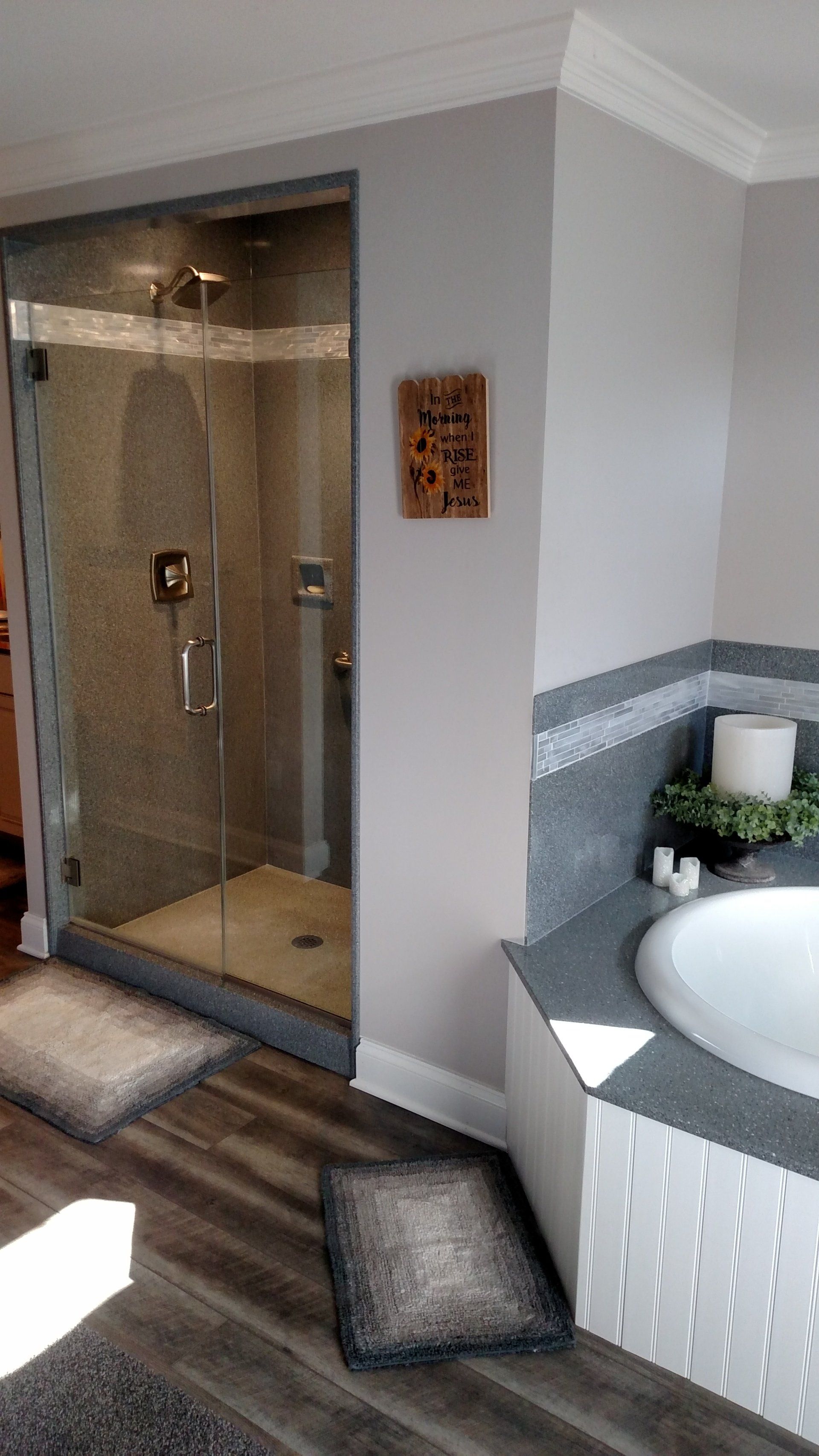 Bathroom with a glass shower, soaking tub, and gray tile accents.