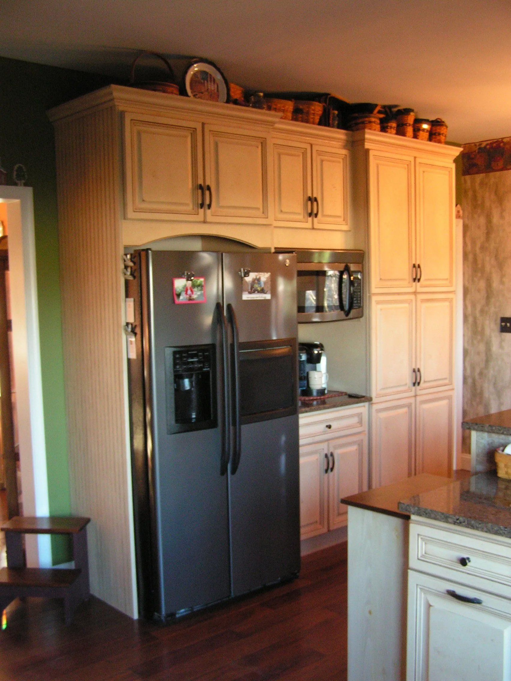 Kitchen with stainless steel refrigerator, cream cabinets, and countertop appliances.