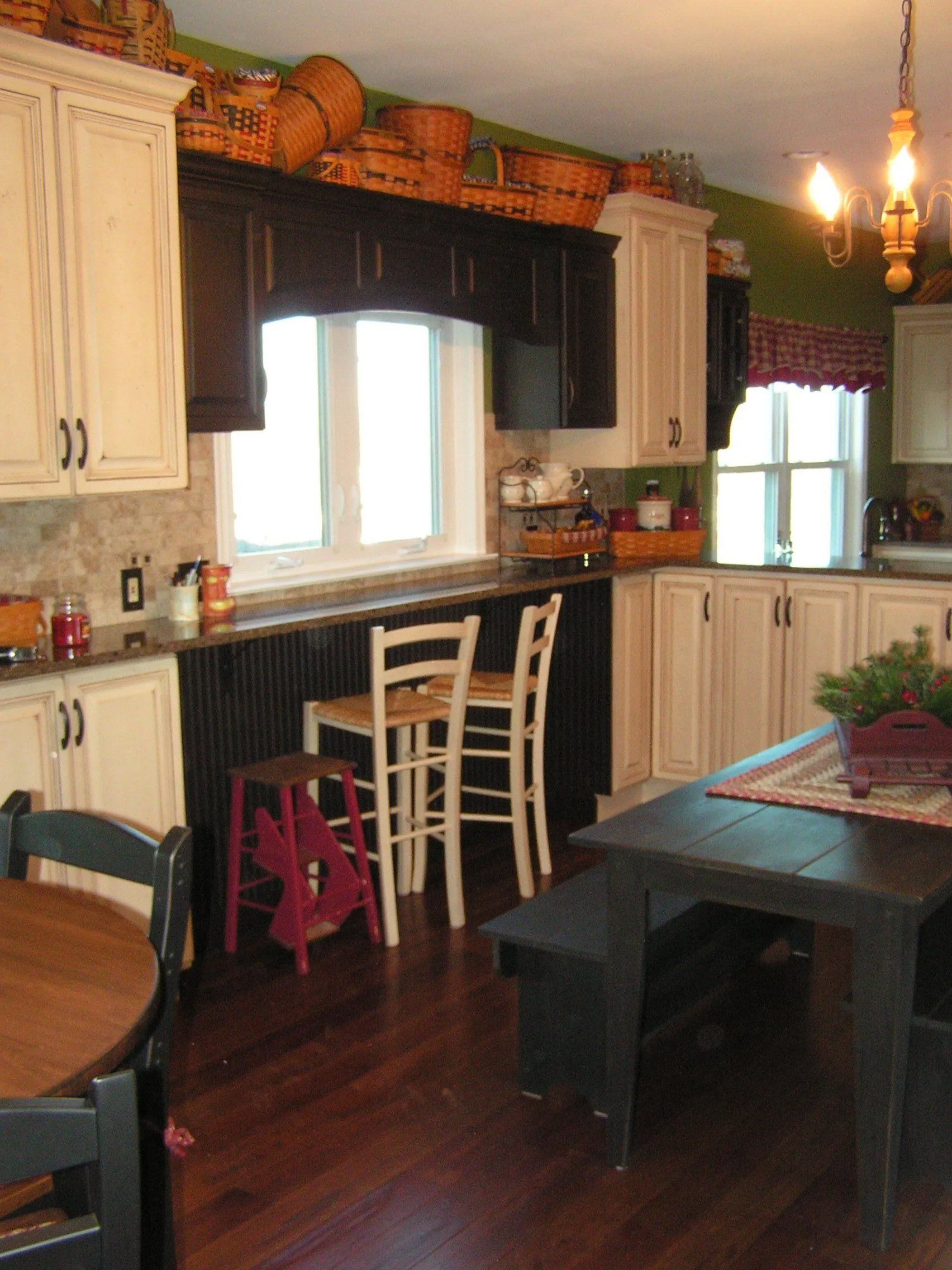 Kitchen with cream cabinets, dark countertop, black and white window trim. Dark wood table and chairs.
