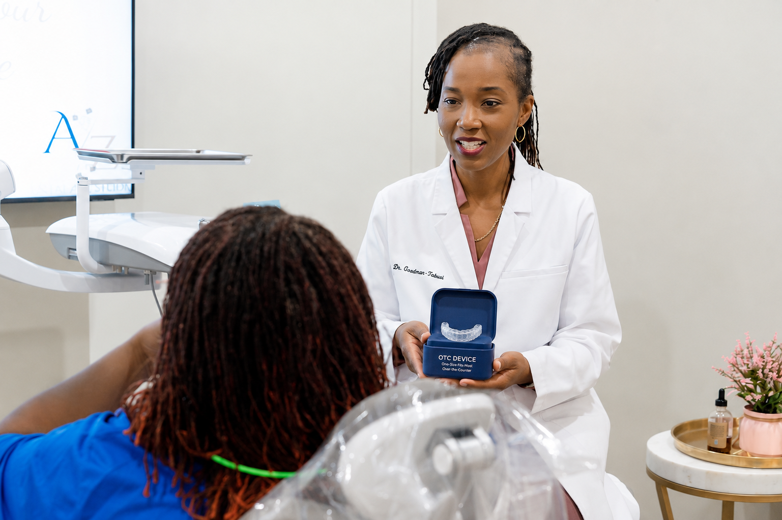 Dentist showing a blue dental case to a patient in a bright clinic room