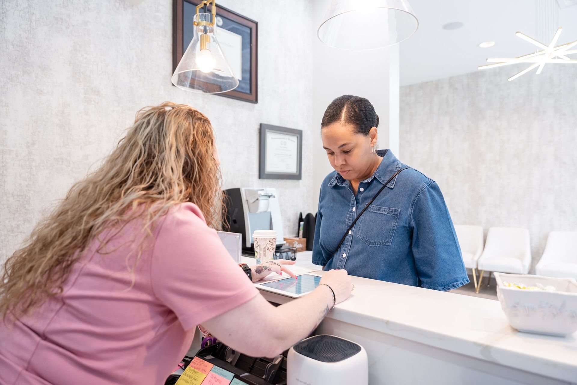 Customer paying at a salon counter while the cashier processes the transaction