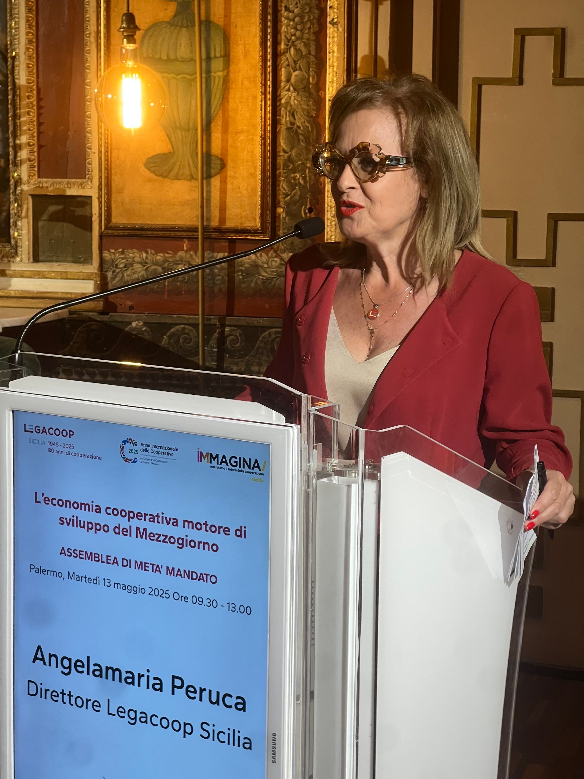 Una donna è in piedi su un podio con un cartello che dice angelaria peruca