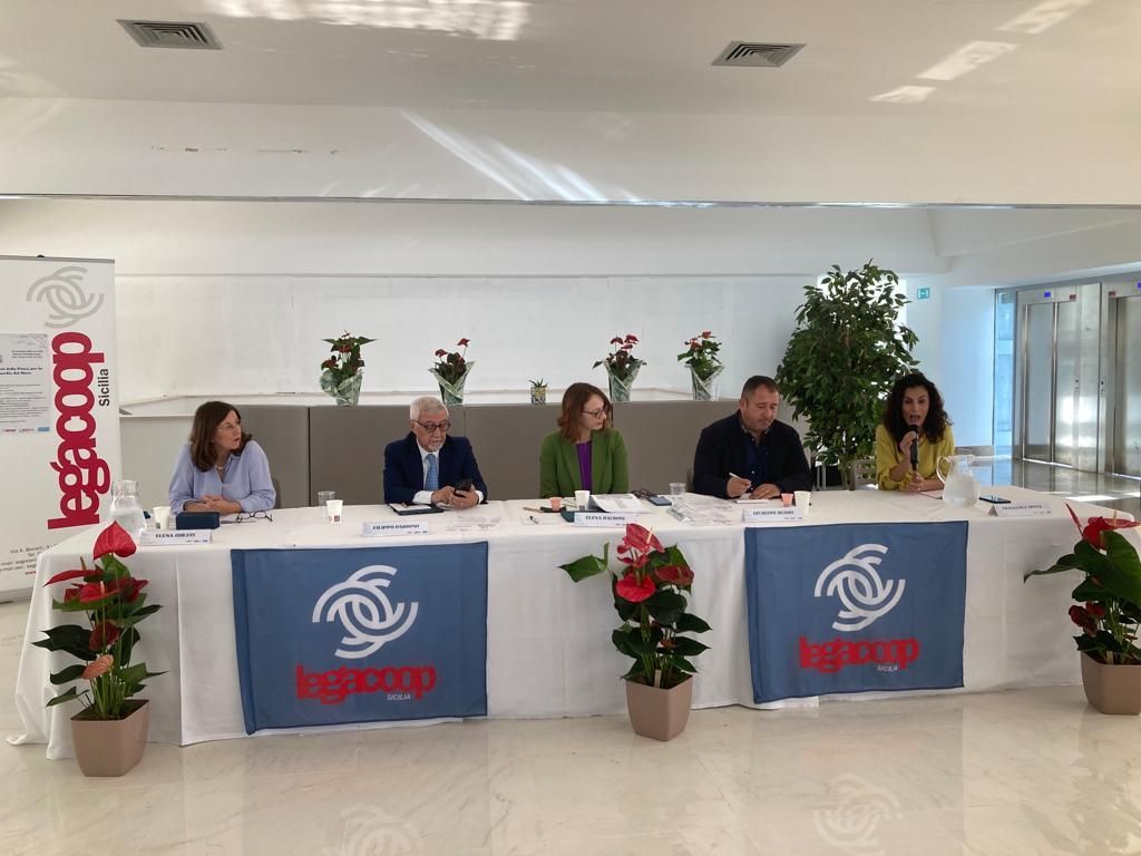 Un gruppo di persone è seduto a un tavolo con un cartello che dice leggroup