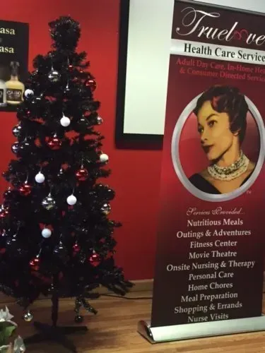 Christmas tree beside a health care service banner in a red-walled room