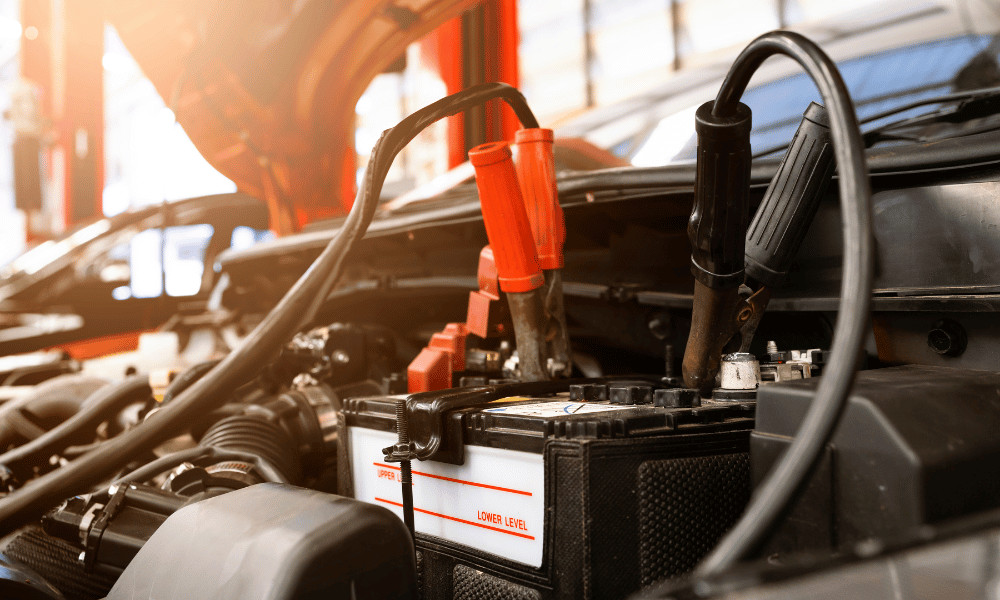 Car battery with jumper cables connected during diagnostic testing