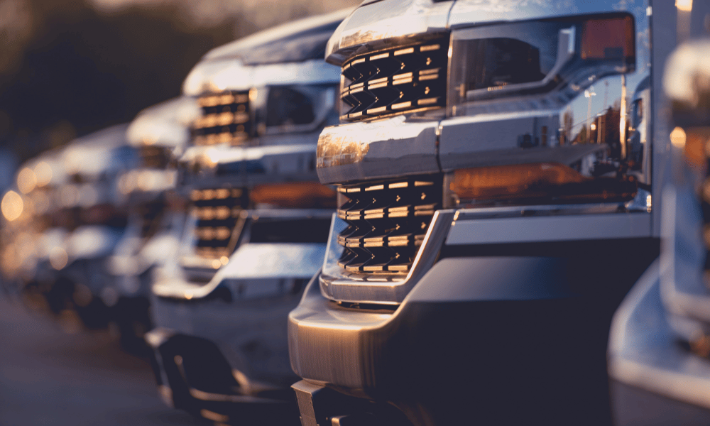 Row of diesel pickup trucks lined up at sunset
