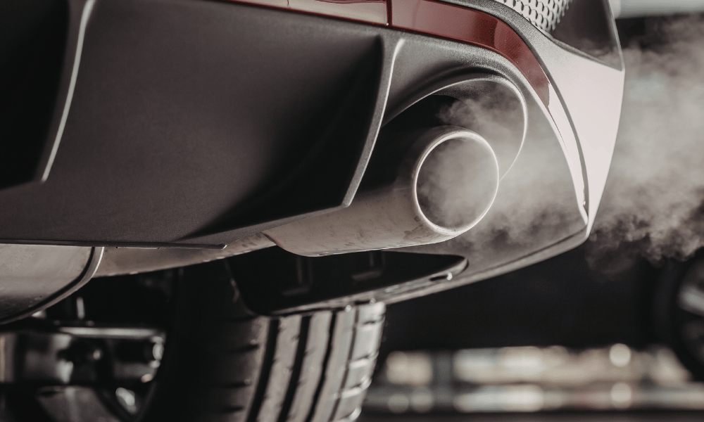 Car exhaust pipe emitting visible smoke from tailpipe