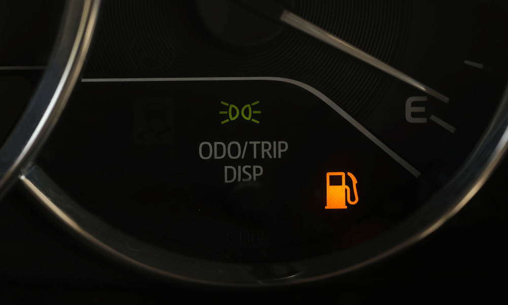Dashboard fuel warning light illuminated indicating low fuel level