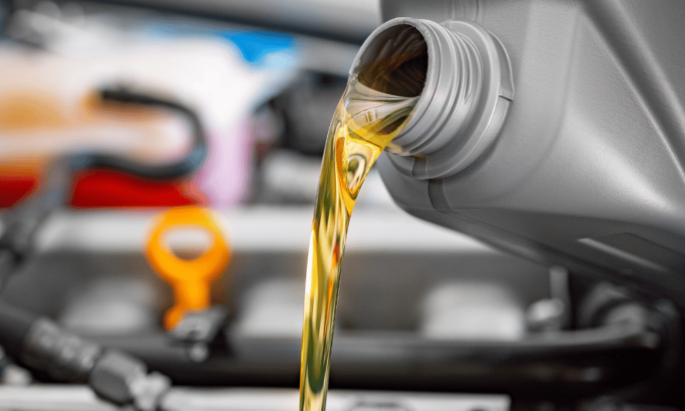 Motor oil being poured into engine during oil change service