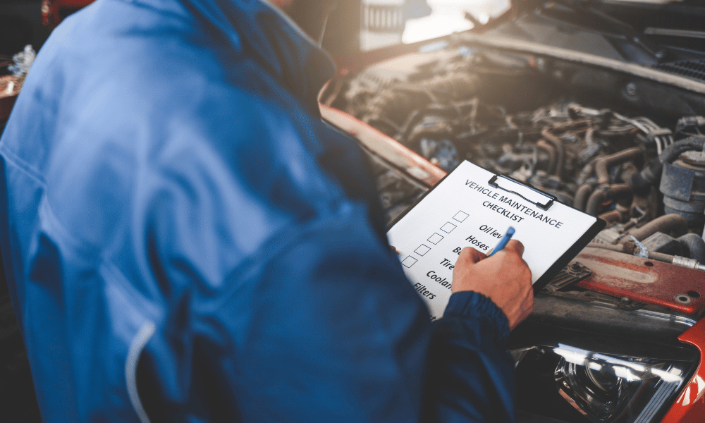 Technician completing scheduled maintenance checklist on vehicle