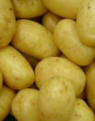 Close-up van opgestapelde gele aardappelen die het hele beeld vullen.