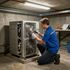 Certified Comfort of Georgia technician working on a business' older unit in a utility room in Flowery Branch GA