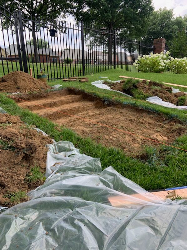 A large pile of dirt is sitting on top of a lush green lawn.