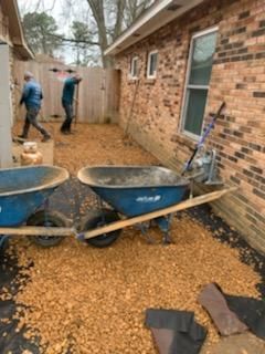 Two wheelbarrows are sitting in front of a brick building.