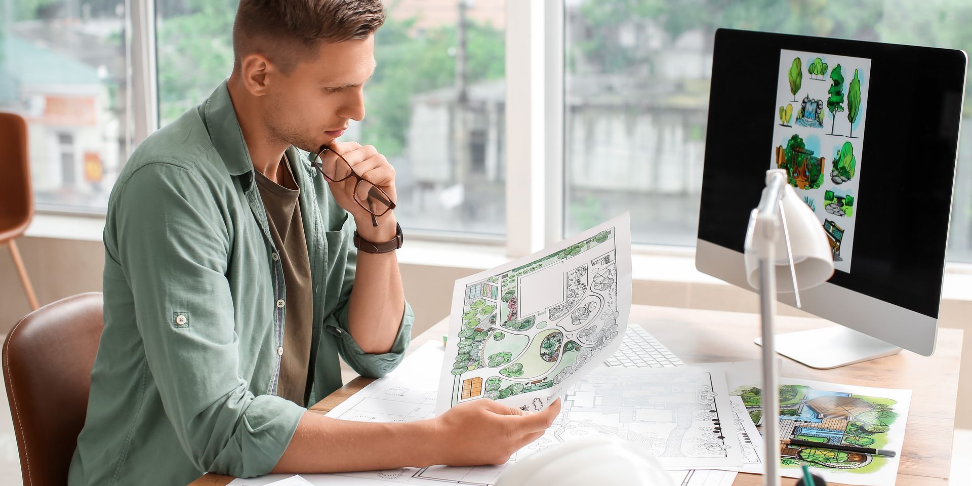 Young male landscape designer working in office. Young male landscape designer working in office.