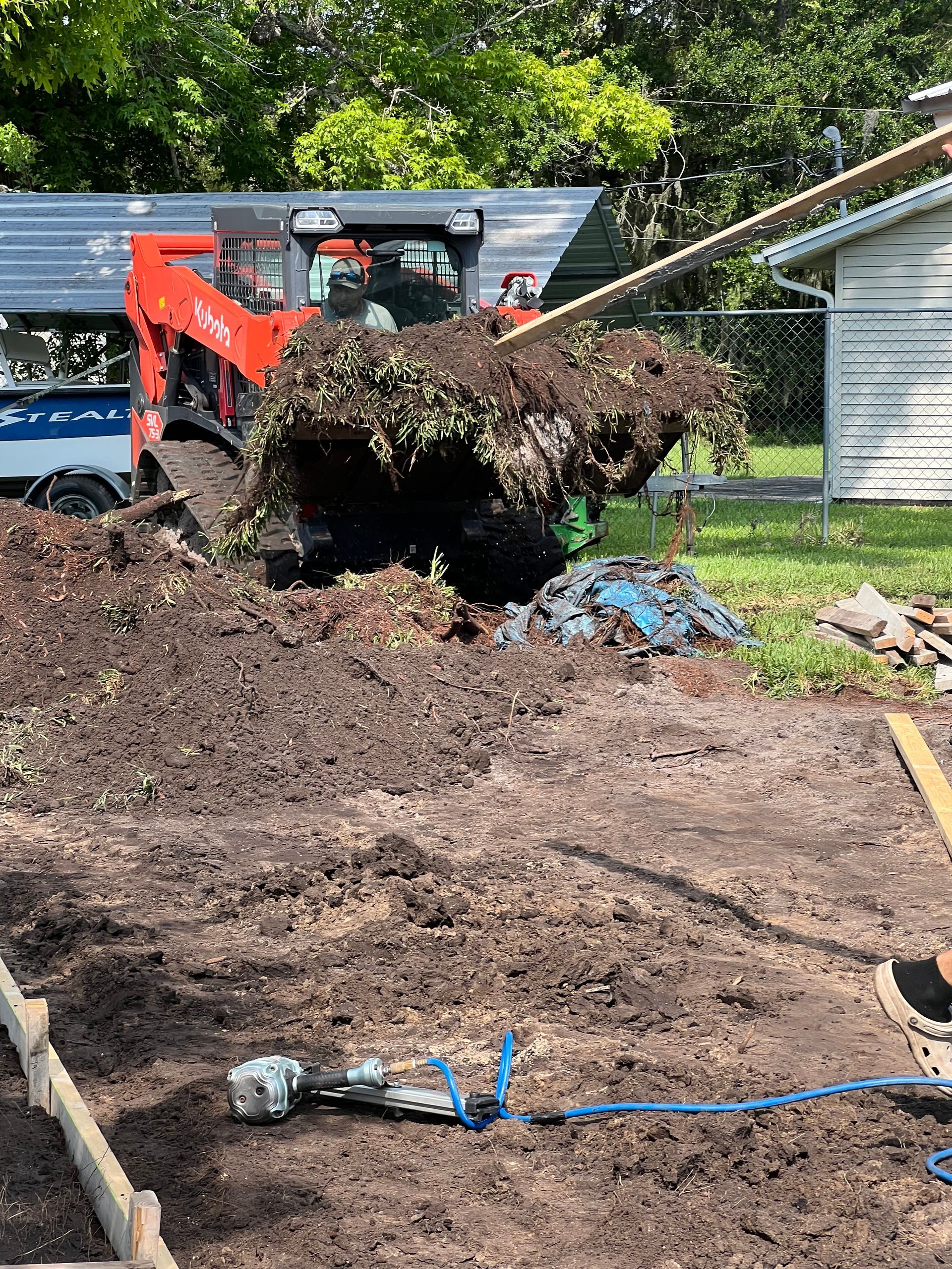 a yellow excavator is working on a dirt road .