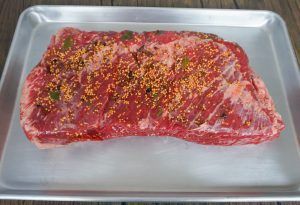 Raw seasoned beef steak on a metal tray