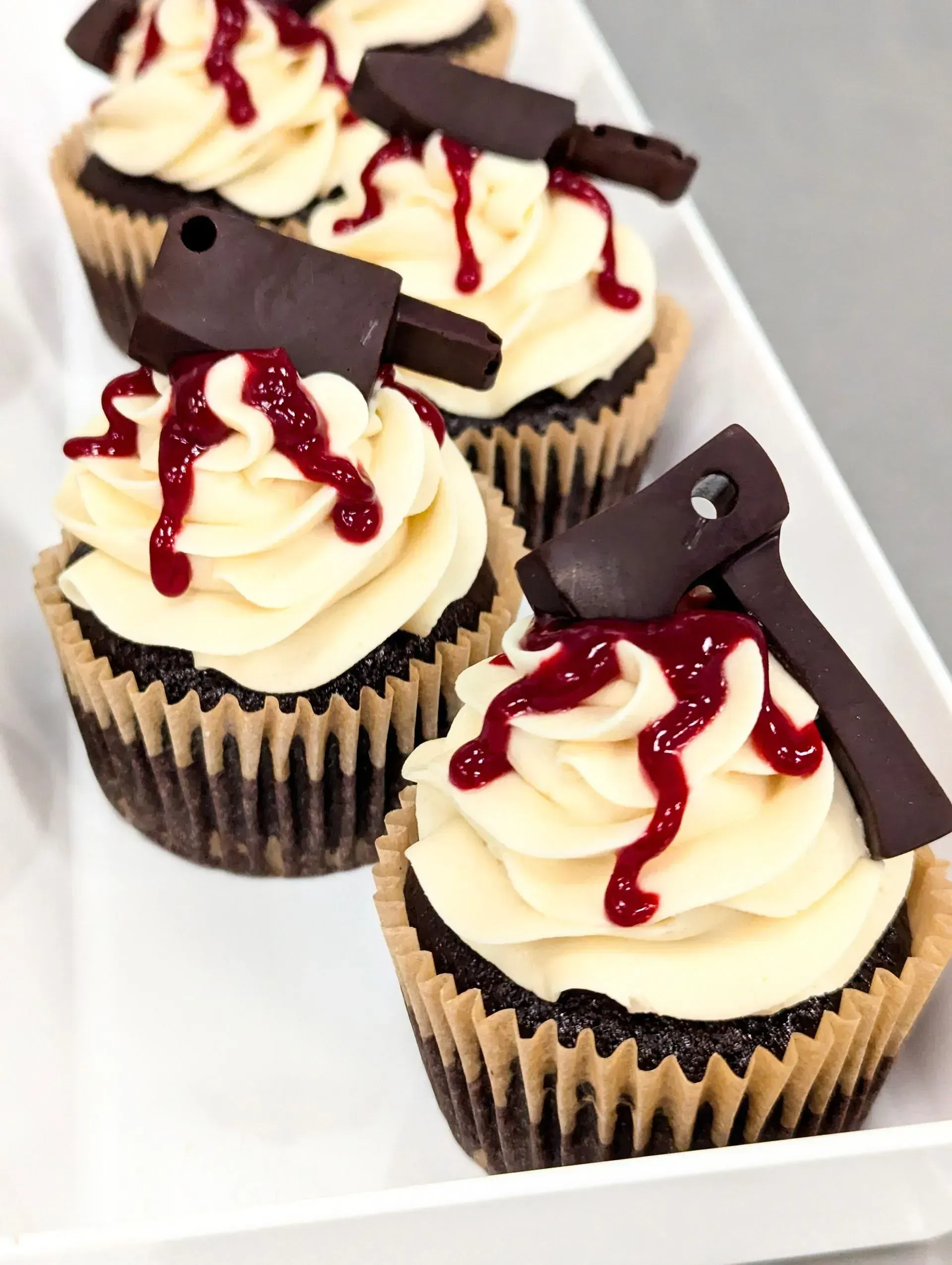 Assorted frosted cupcakes with sprinkles and swirled toppings in various colors, arranged closely together