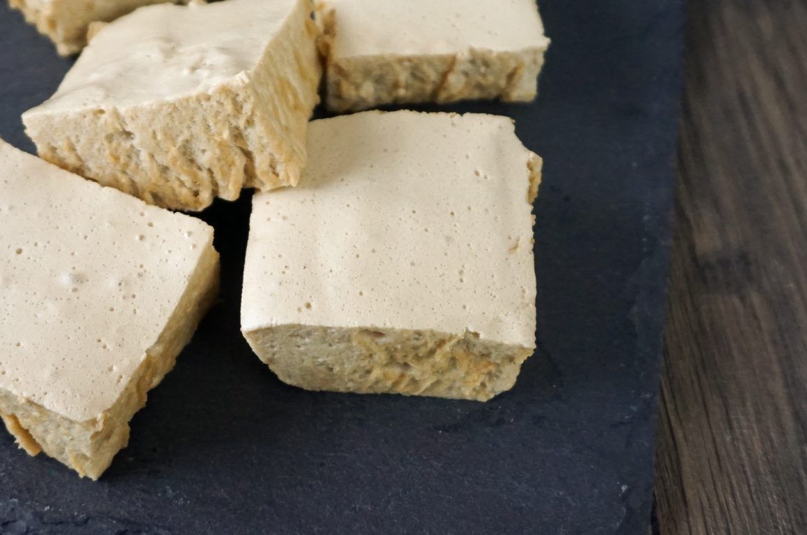 Close-up of beige tofu cubes on a dark slate board