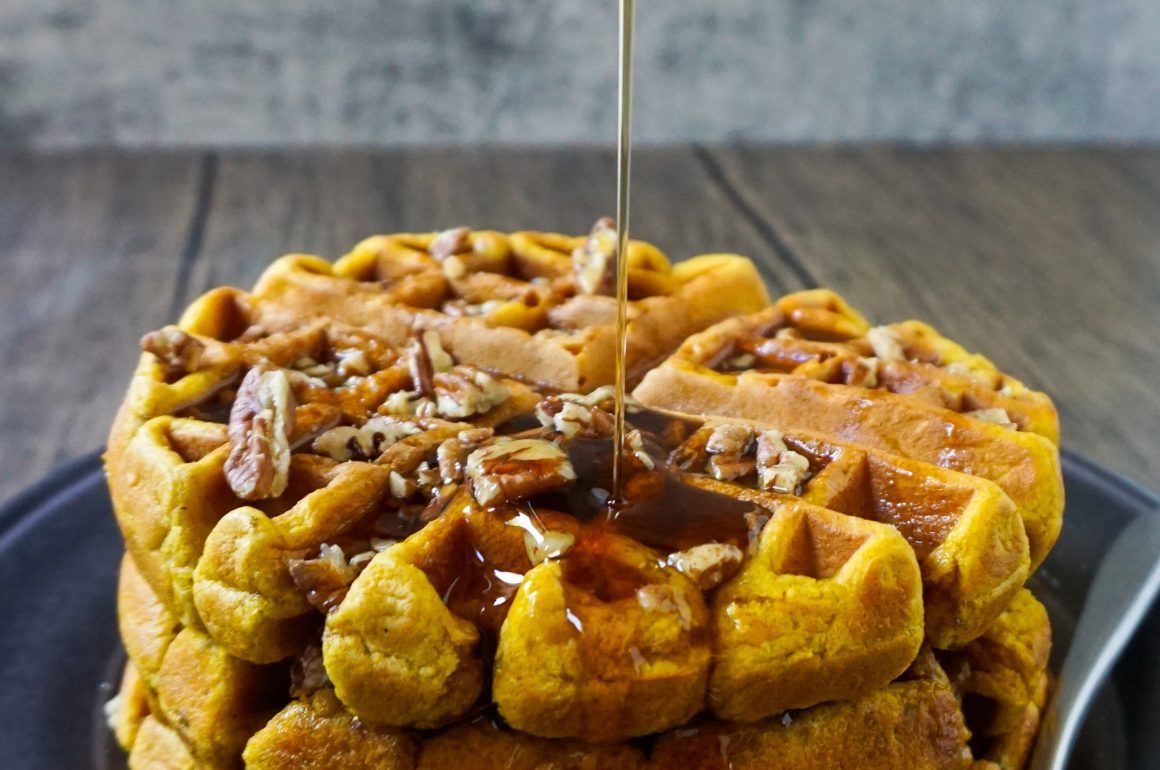 Caramel-topped monkey bread loaf on a plate with syrup dripping over the center
