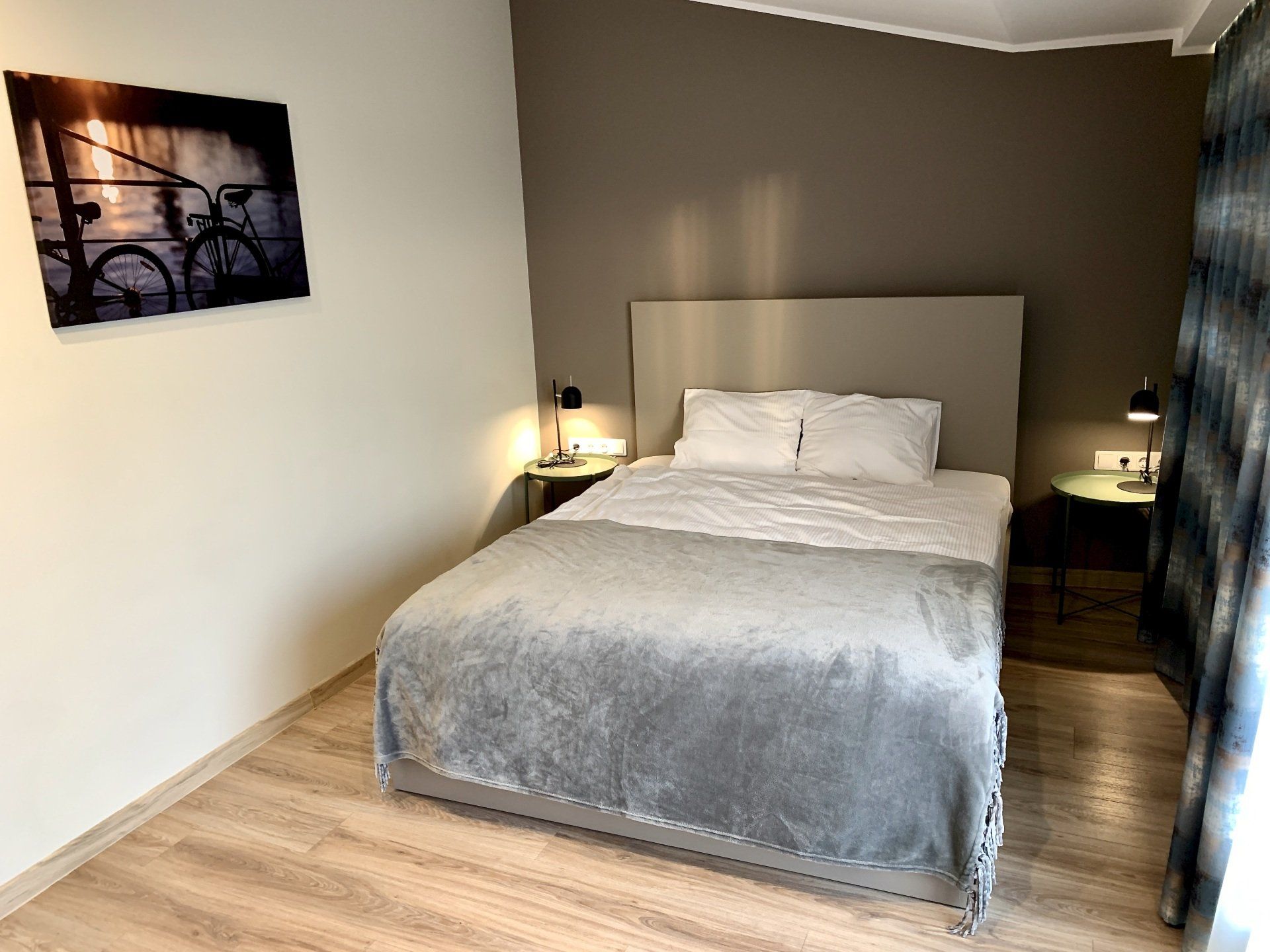 There is a picture of a bicycle on the wall above the bed.