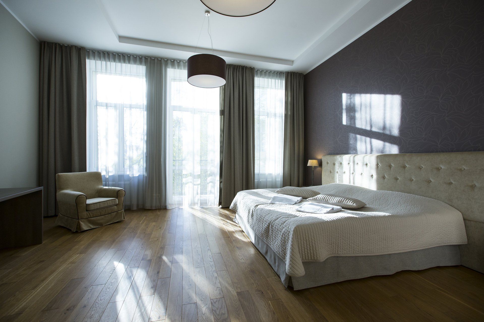 A bedroom with a large bed and a chair