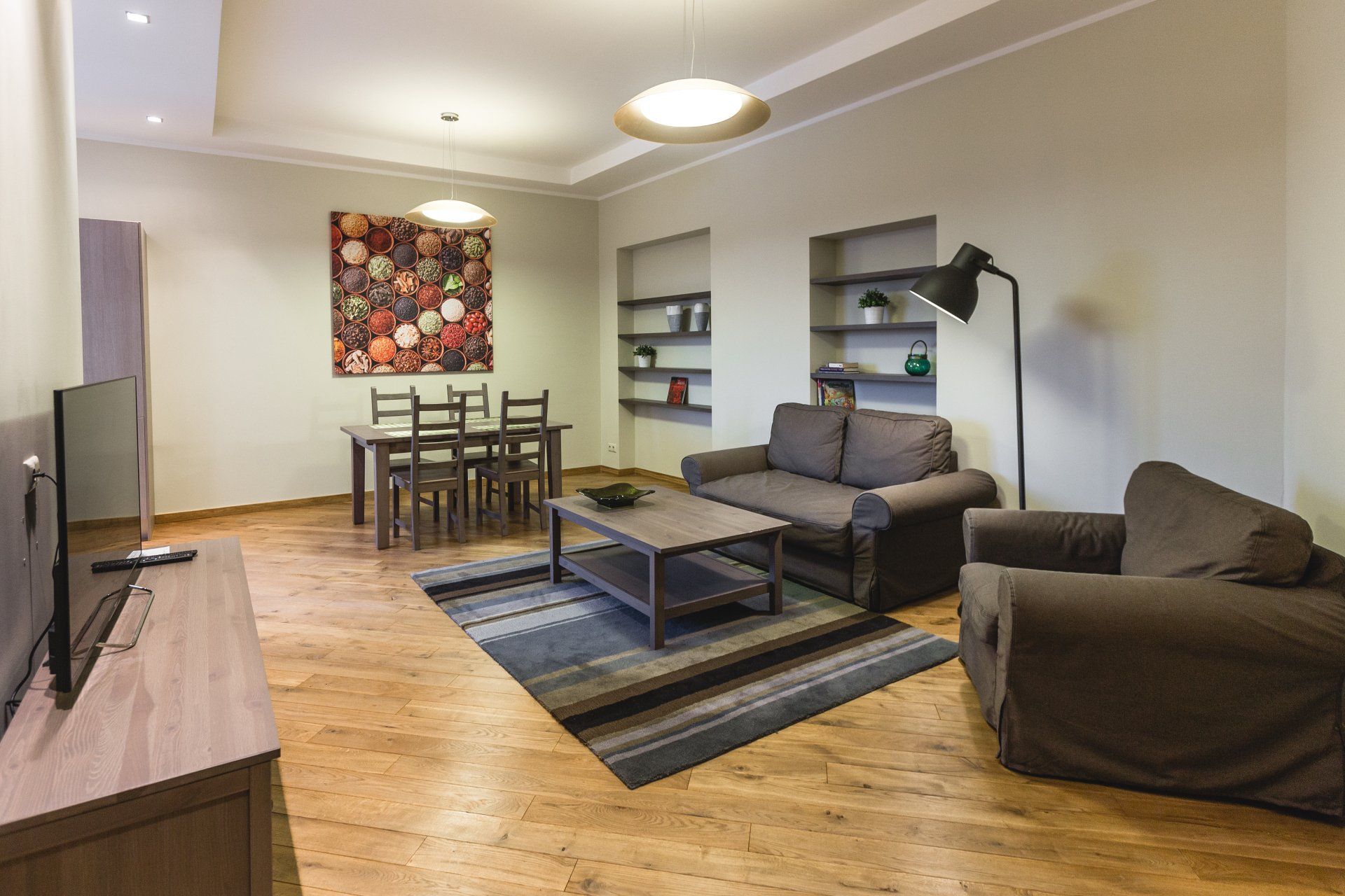 A living room with a couch , chair , table and television.