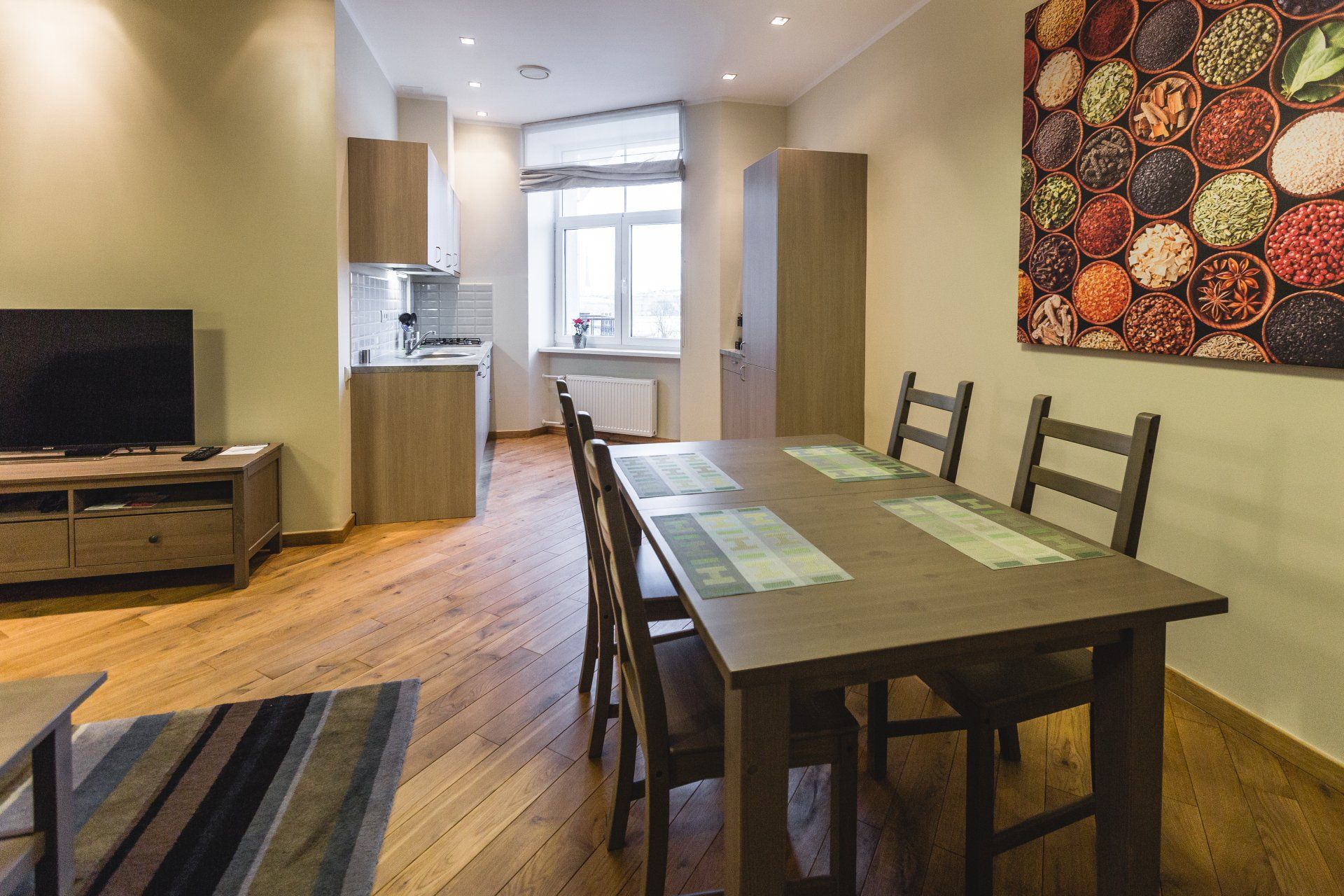 A living room with a dining table and chairs and a television.