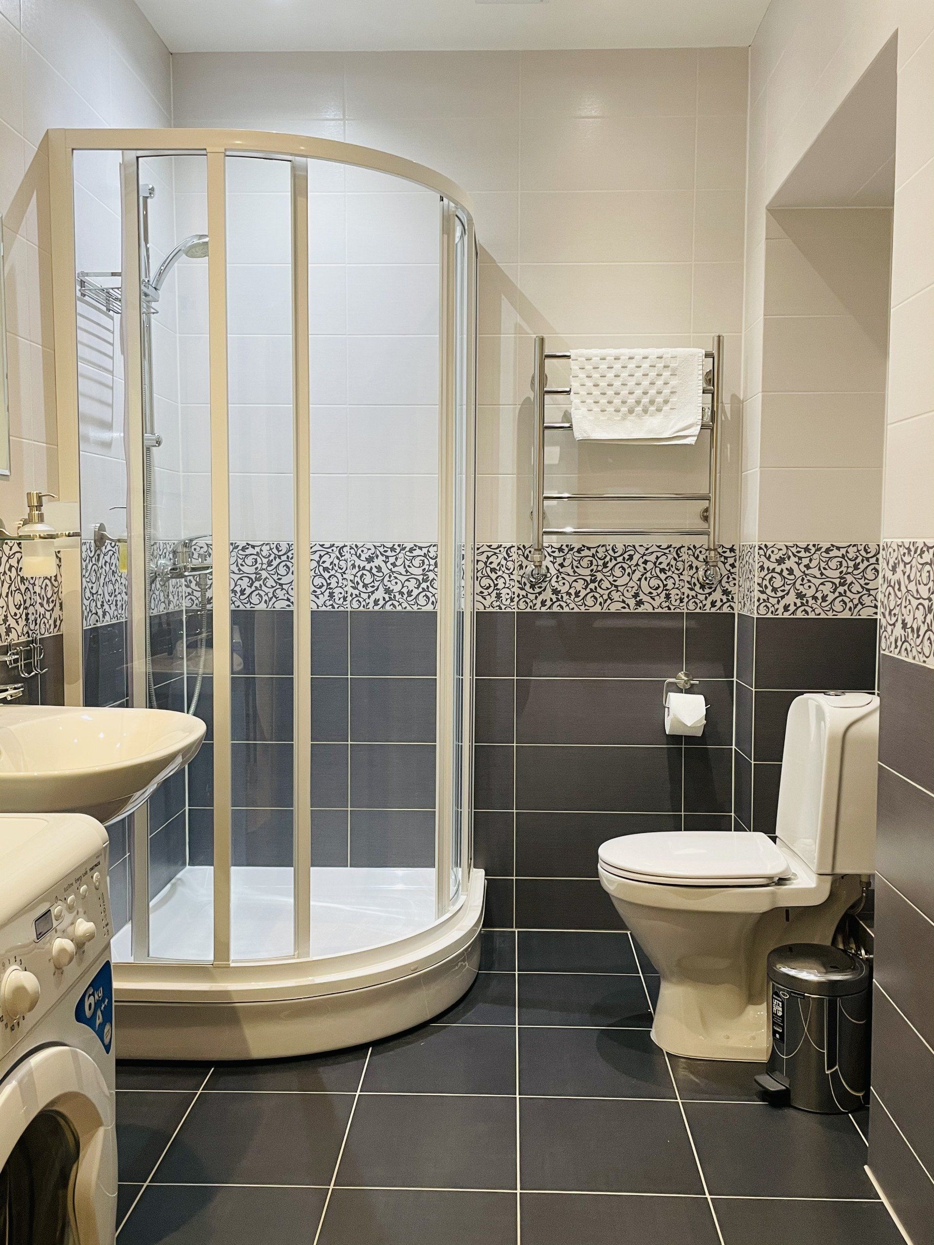 A bathroom with a toilet a sink and a shower stall