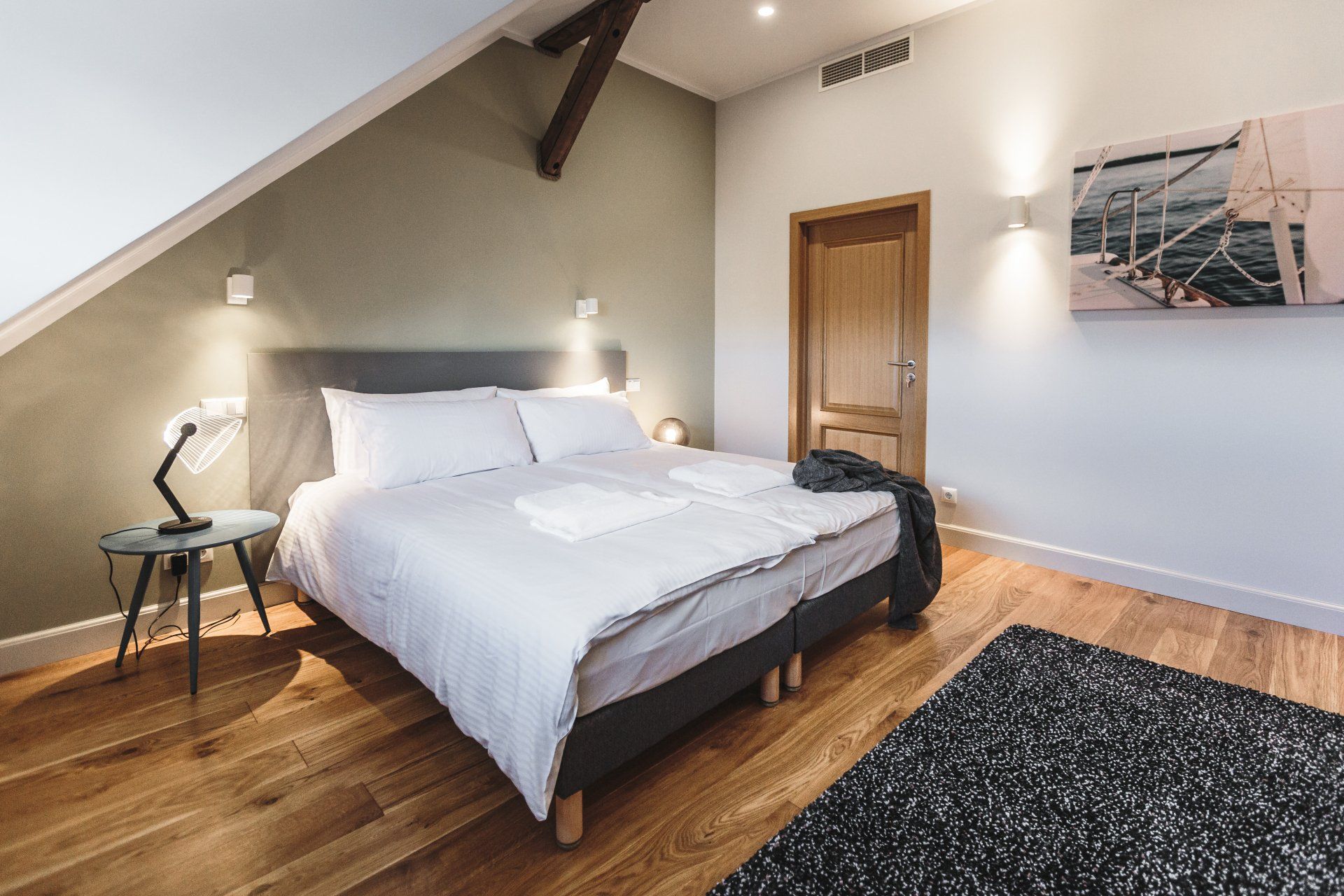 A bedroom with a king size bed and a rug on the floor.