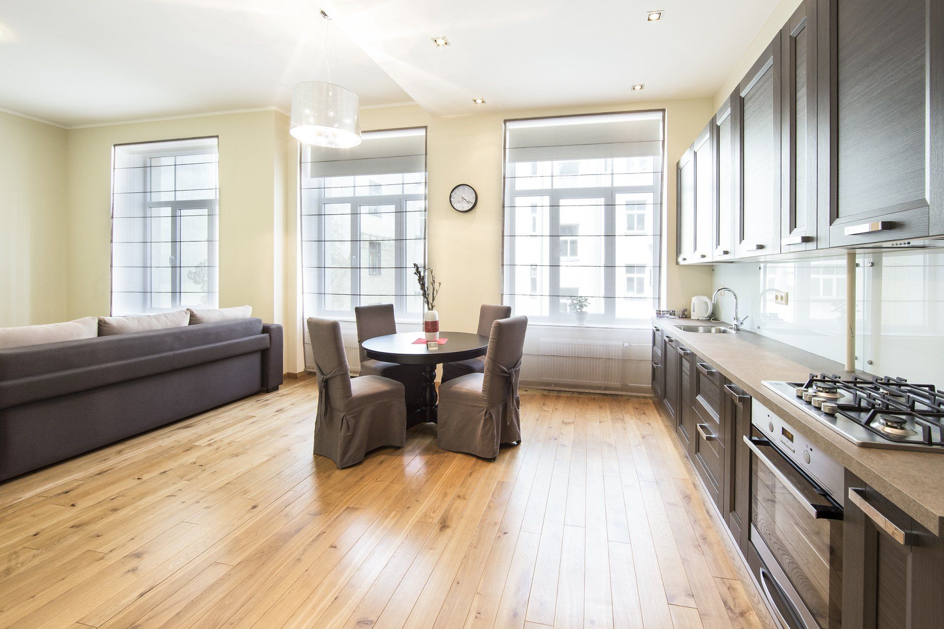 A kitchen with a table and chairs in it and a couch in the background.