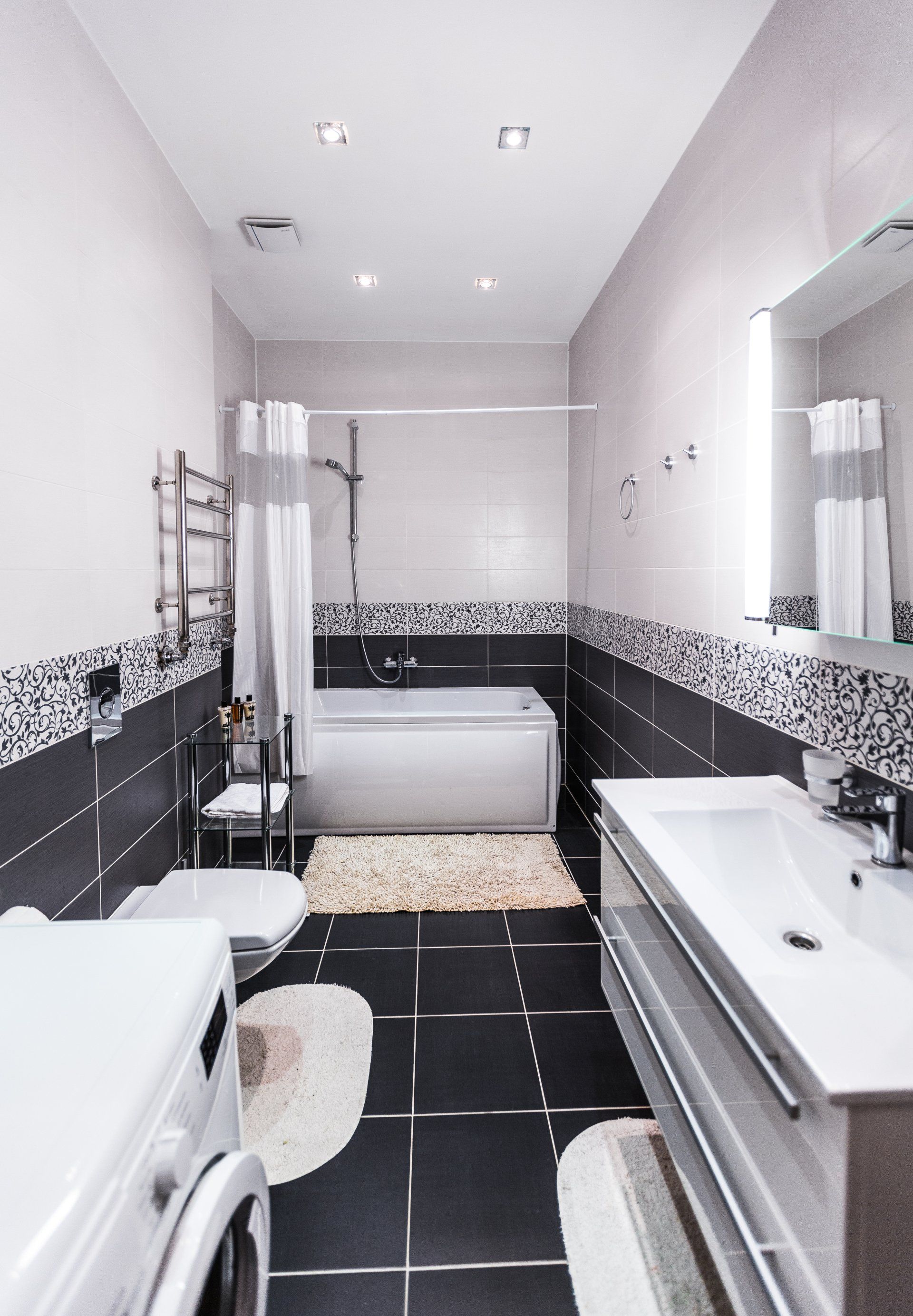 A bathroom with a bathtub , sink , toilet and mirror.