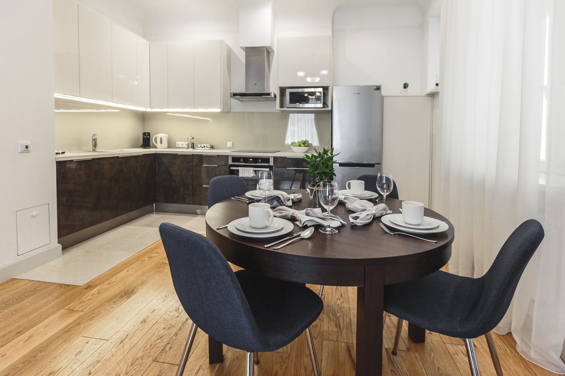A kitchen with a round table and chairs in it
