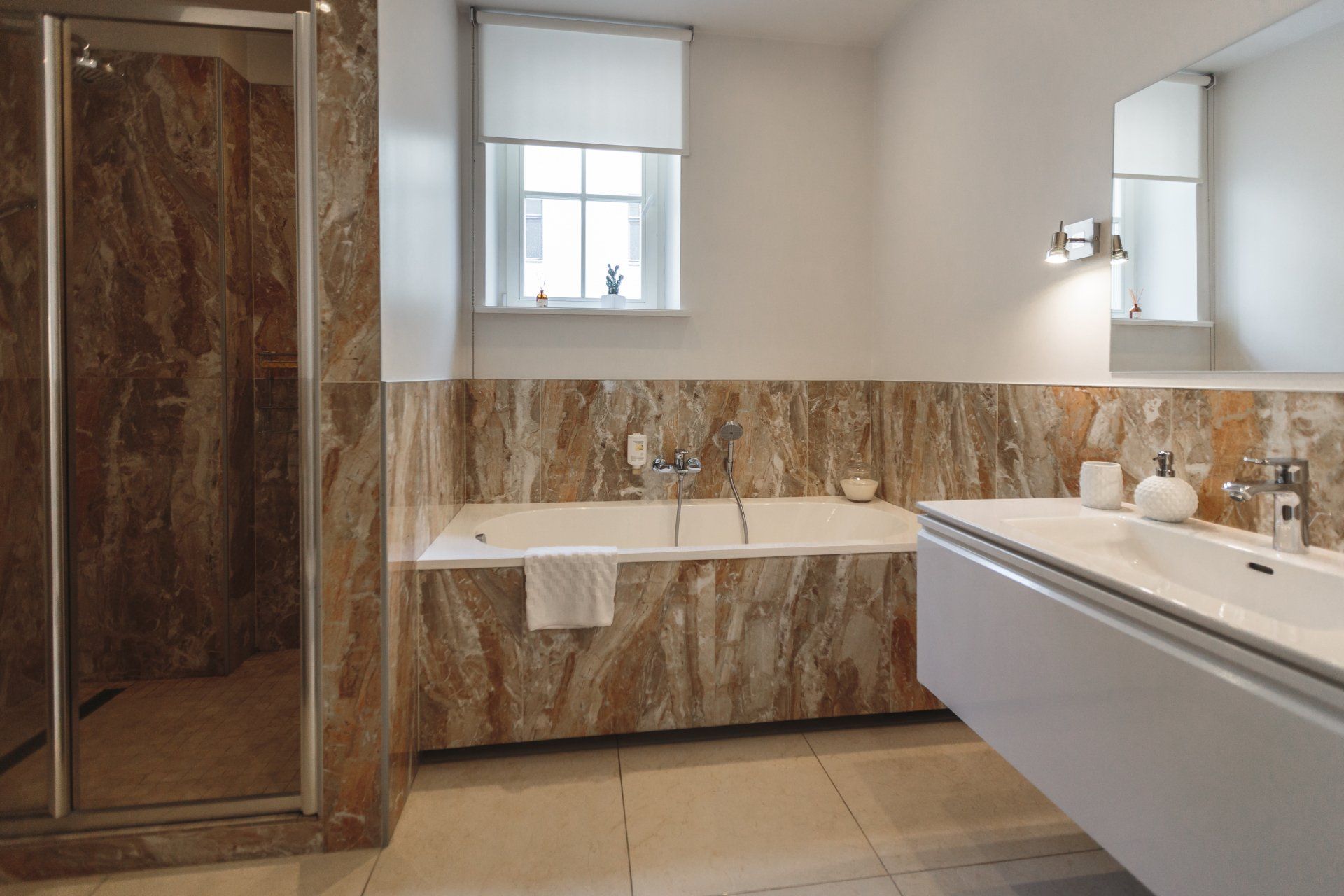 A bathroom with a bathtub , sink , and shower.