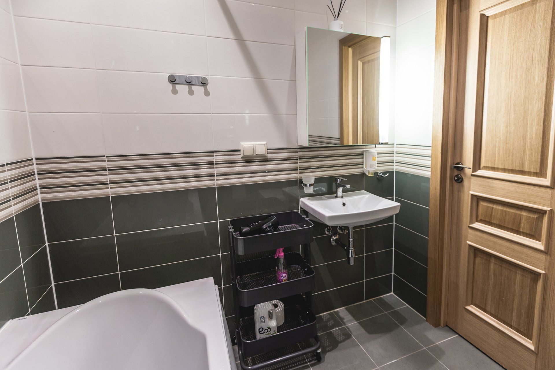 A bathroom with a tub , sink and mirror