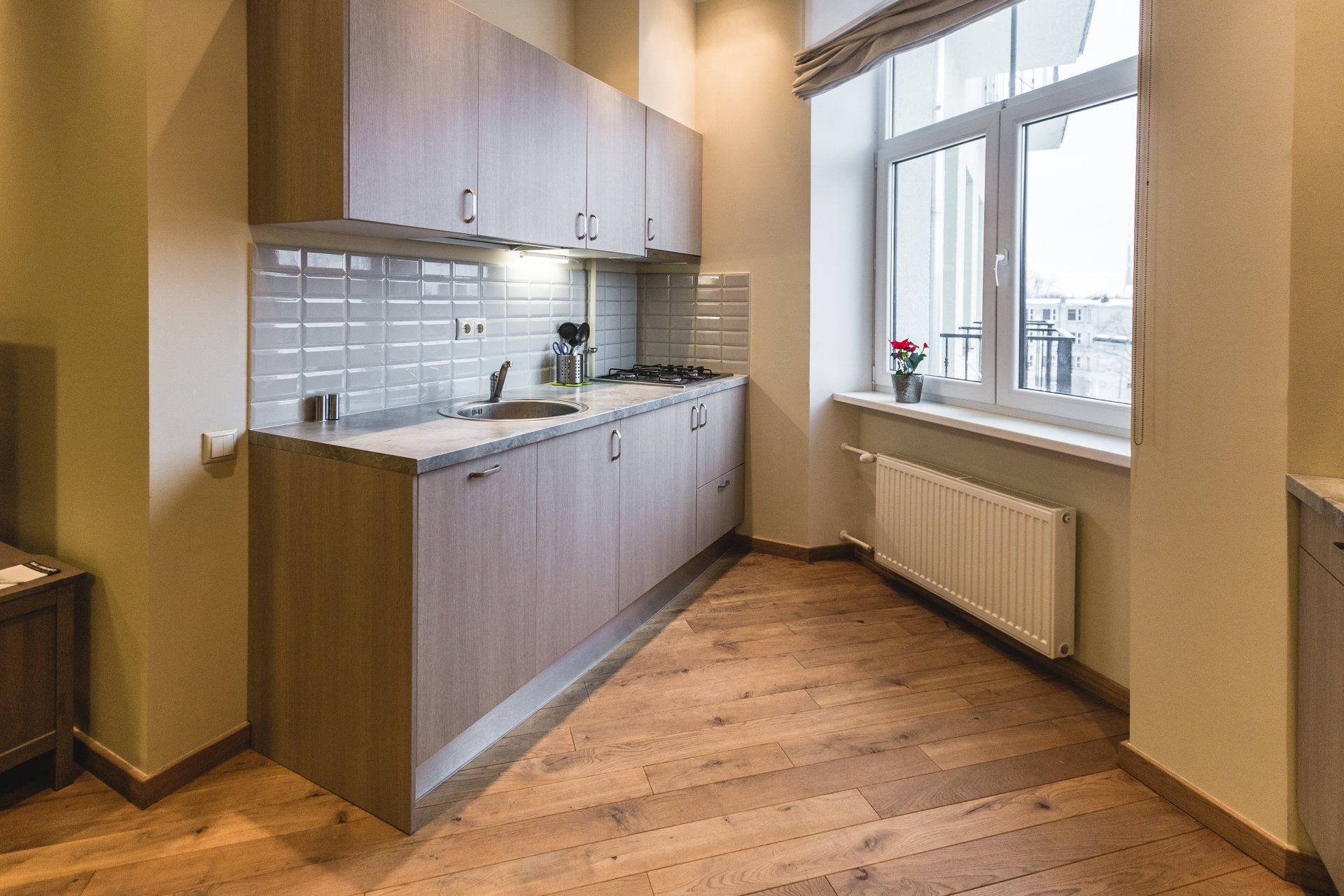 A kitchen with wooden cabinets , a sink , and a window.