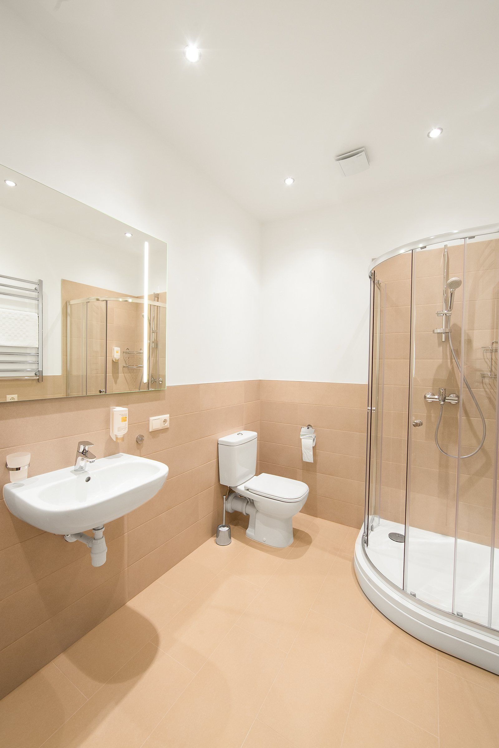 A bathroom with a toilet , sink and shower.
