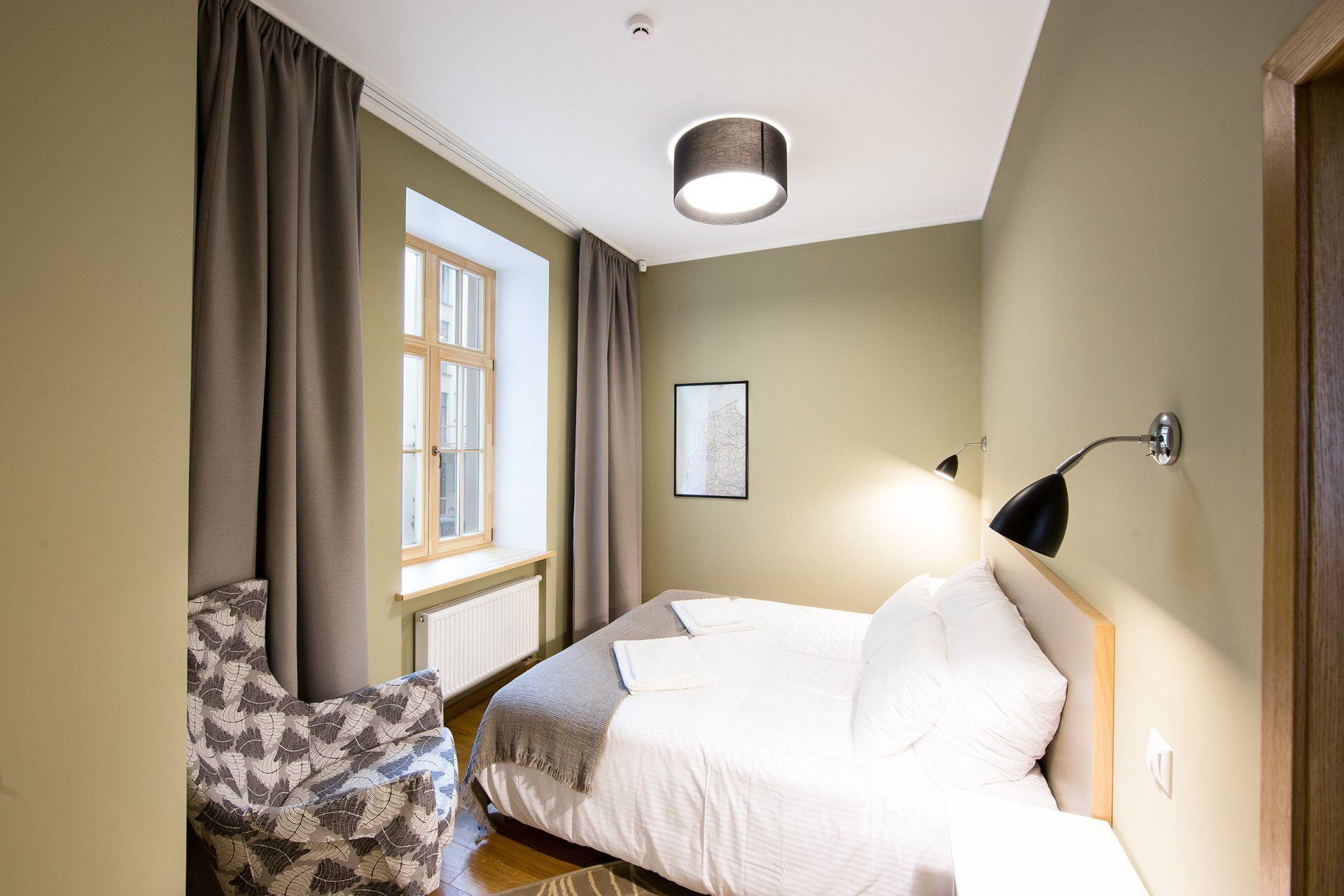 A bedroom with a bed , chair and window.