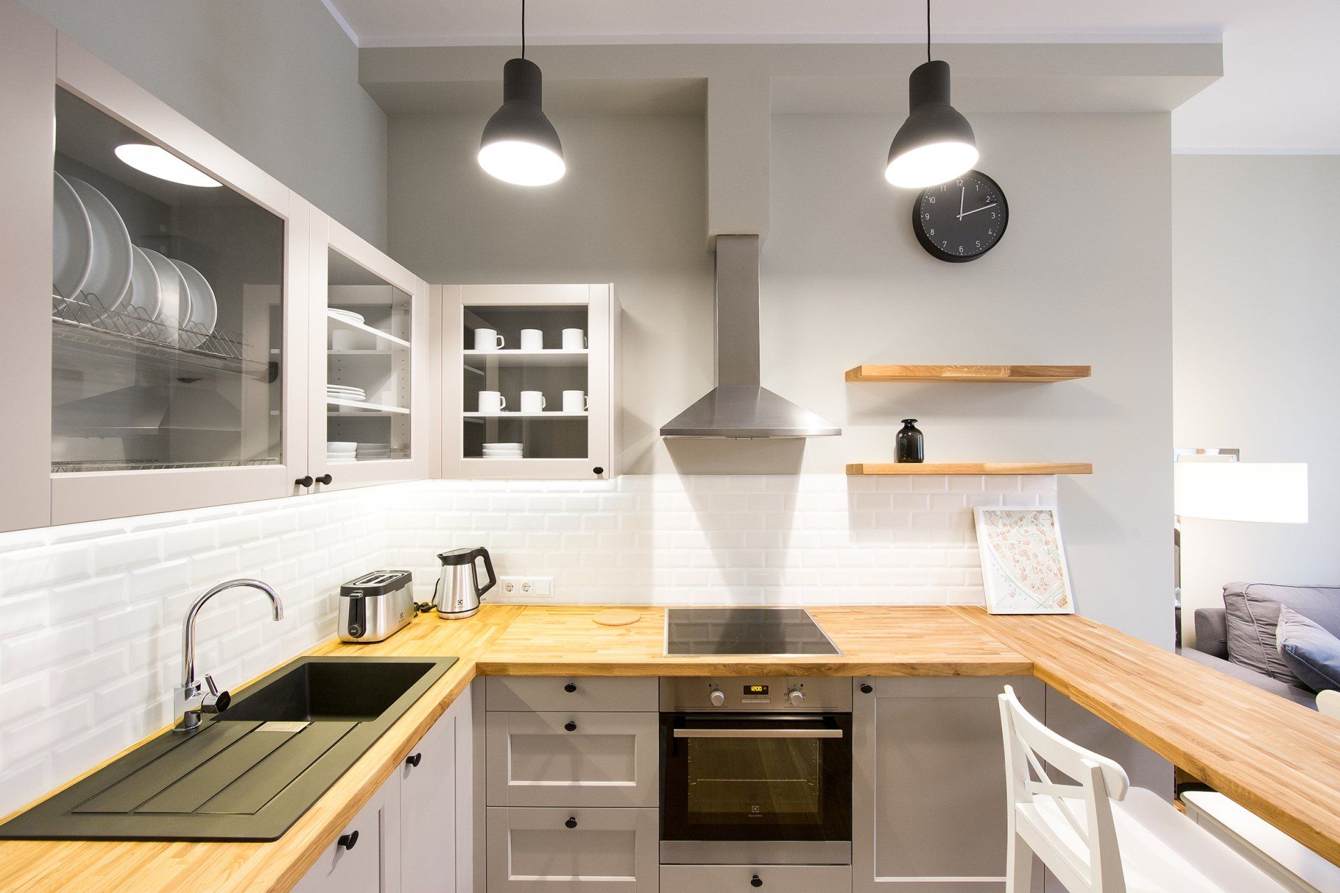 A kitchen with white cabinets , wooden counter tops , a sink and a stove.