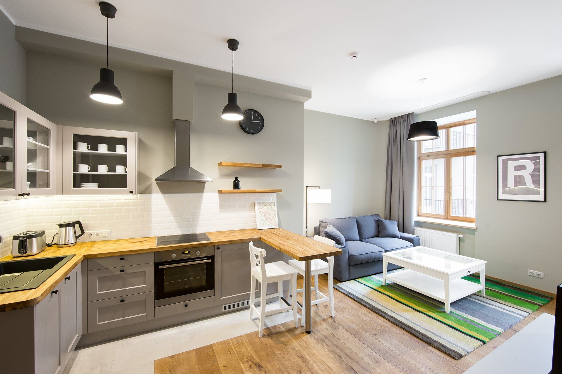 A kitchen and living room in a small apartment with a couch and table.