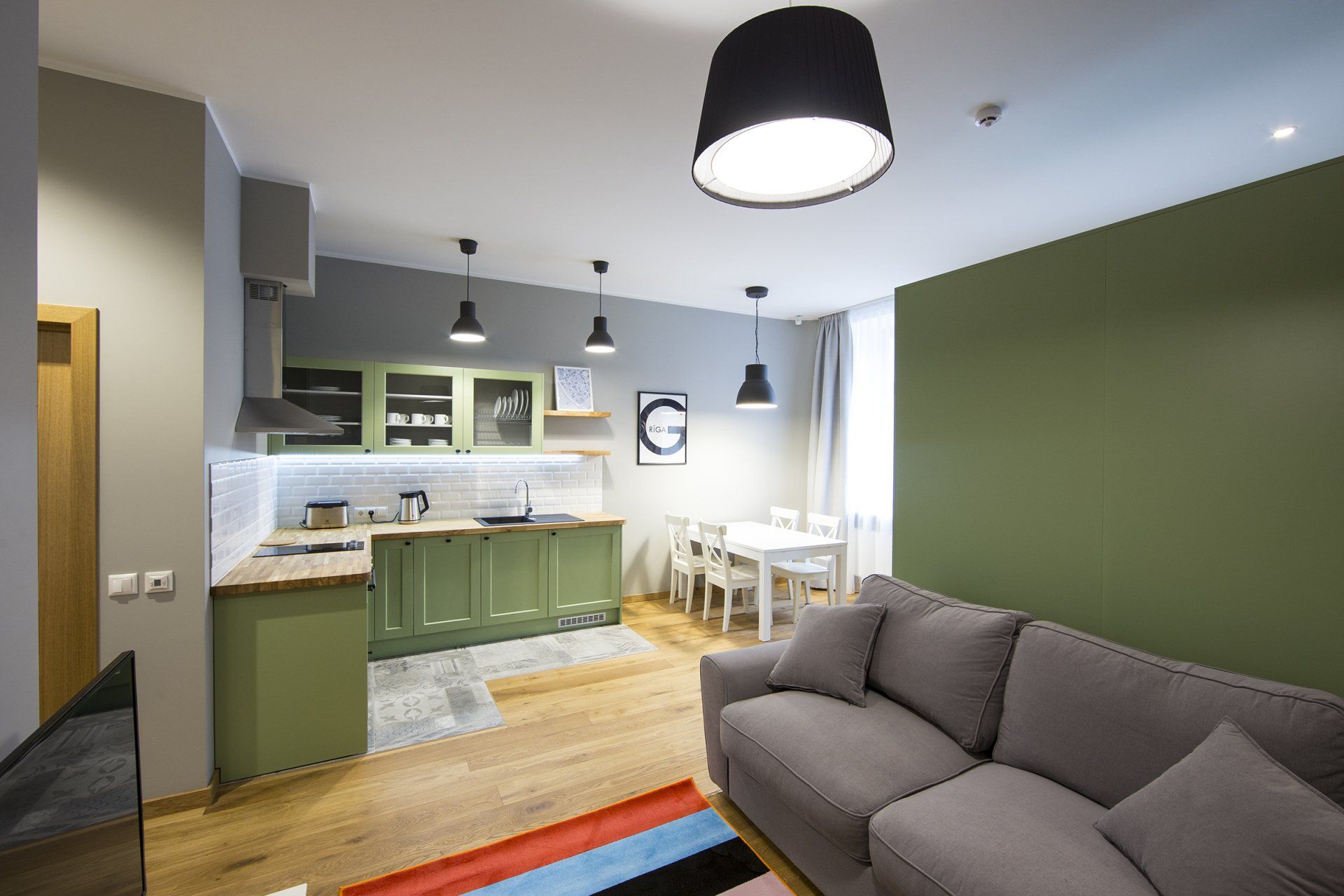 A living room with a couch and a kitchen in the background.