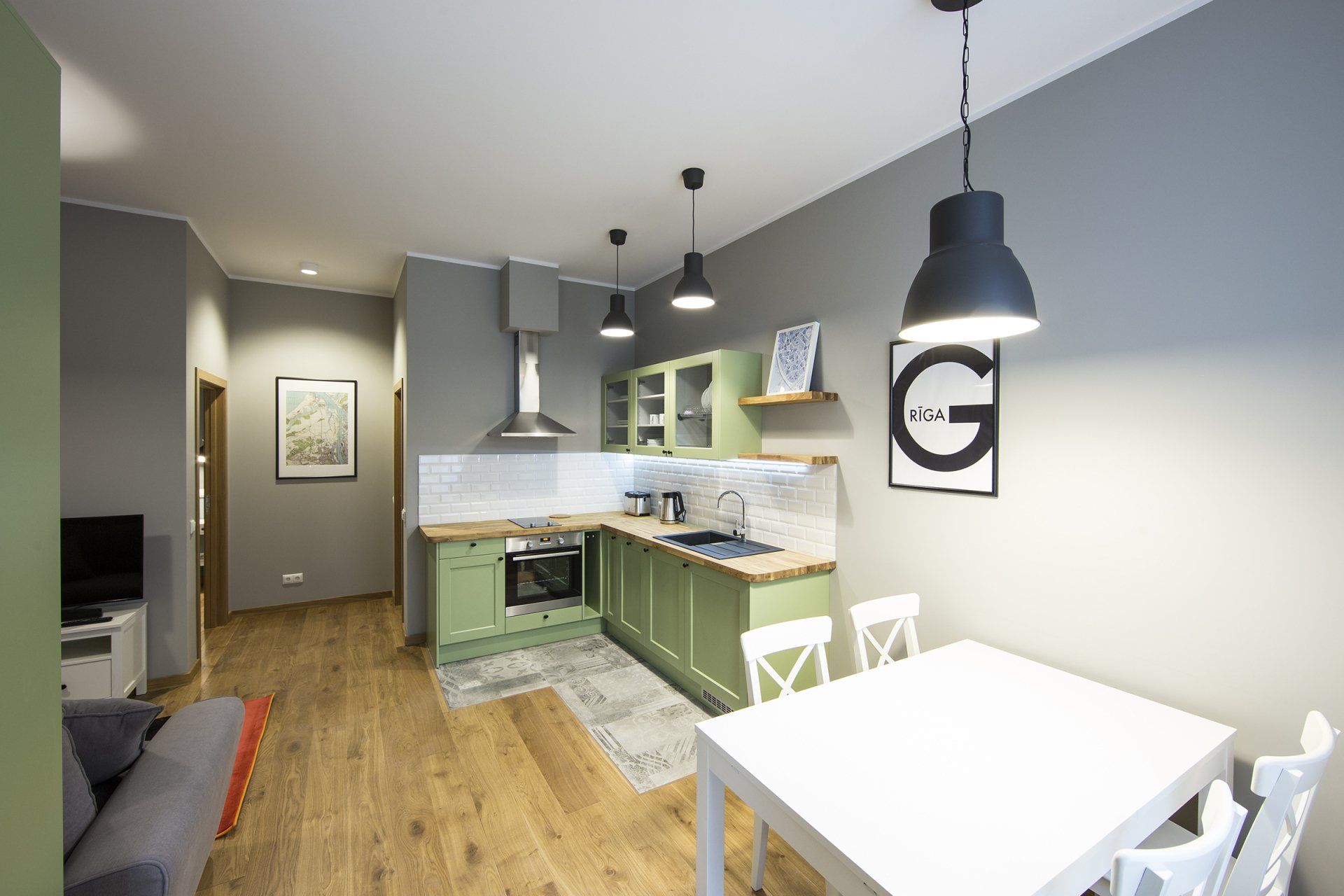 A kitchen with green cabinets and a white table and chairs