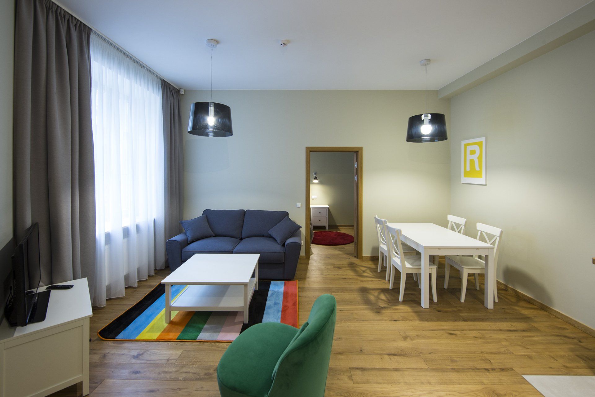 A living room with a couch , chair , table and television.