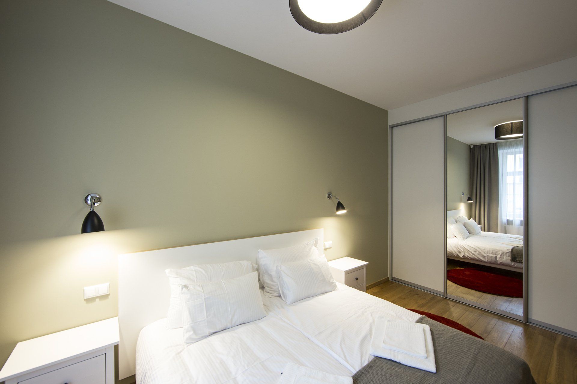 A bedroom with a bed , nightstand , and sliding glass doors.